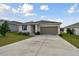 One-story house with a two-car garage and a grassy yard at 1734 Hill Top Dr, Dundee, FL 33838