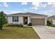 Front view of a one-story house with a two-car garage at 1734 Hill Top Dr, Dundee, FL 33838