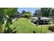 Lush backyard featuring a boat lift, a pool area, mature trees, and vibrant greenery at 225 Temple Cir, Eustis, FL 32726