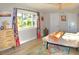 Bright bedroom with a colorful rug, curtains, light wood floors, and a modern dresser at 225 Temple Cir, Eustis, FL 32726