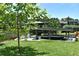 Boat dock featuring a covered boat lift on the water, surrounded by green grass and mature trees at 225 Temple Cir, Eustis, FL 32726