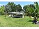 Private boat dock with a covered lift on a tranquil waterway surrounded by lush greenery at 225 Temple Cir, Eustis, FL 32726