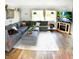 Living area features a sectional sofa, a large TV, and wood flooring at 225 Temple Cir, Eustis, FL 32726