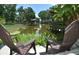 Relaxing patio area with chairs overlooking a tranquil water view with lush vegetation at 225 Temple Cir, Eustis, FL 32726
