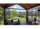Screened patio with a lounge area and a view of the lush backyard, pond, and boat dock at 225 Temple Cir, Eustis, FL 32726