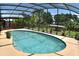 Sparkling pool surrounded by beautiful landscaping and covered sitting area, perfect for outdoor relaxation at 225 Temple Cir, Eustis, FL 32726