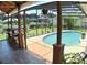 Screened patio with a dining area and a view of the pool and lush landscaping at 225 Temple Cir, Eustis, FL 32726