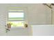 Shower with decorative wall tile, rainfall shower head, window, and a small plant at 225 Temple Cir, Eustis, FL 32726