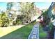 Landscaped side yard with stone pathway and lush tropical plants at 225 Temple Cir, Eustis, FL 32726