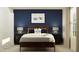 Bedroom with navy blue accent wall, dark wood bed frame, and window at 3450 Howell Dr, Lake Wales, FL 33859