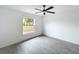 A simple bedroom with wood-look flooring, neutral walls, a window and a ceiling fan at 2449 Jungle St, Lakeland, FL 33801