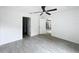 A simple bedroom with wood-look flooring, neutral walls, and a ceiling fan at 2449 Jungle St, Lakeland, FL 33801