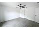 A simple bedroom with wood-look flooring, neutral walls, and a ceiling fan at 2449 Jungle St, Lakeland, FL 33801