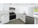 Well-lit kitchen featuring stainless steel appliances, white cabinetry, and modern fixtures at 2449 Jungle St, Lakeland, FL 33801