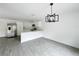 Modern kitchen featuring white cabinets, stainless steel appliances, breakfast bar, and a geometric modern chandelier at 2449 Jungle St, Lakeland, FL 33801