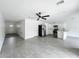 Open-concept living space featuring tile floors, modern ceiling fan, with kitchen featuring white cabinets and stainless appliances at 2449 Jungle St, Lakeland, FL 33801