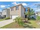 Attractive two-story home with a two-car garage, red shutters, and nicely landscaped front yard at 163 Tiny Flower Rd, Davenport, FL 33837