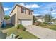 Inviting two-story house with a two-car garage, red shutters, and a manicured lawn at 163 Tiny Flower Rd, Davenport, FL 33837