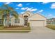 Tan one-story house with a two-car garage and palm tree at 1066 Krenson Woods Rd, Lakeland, FL 33813