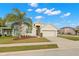 Tan one-story house with a two-car garage and palm tree at 1066 Krenson Woods Rd, Lakeland, FL 33813