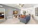 Living room with gray walls, comfy couch, and a large TV at 1066 Krenson Woods Rd, Lakeland, FL 33813