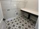 Neat laundry room features sleek countertop, patterned floor, and overhead shelving at 1701 Ferris Ave, Orlando, FL 32803