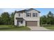 Two-story home with gray siding, brown garage door, and landscaping at 2017 Lasso Loop, Eagle Lake, FL 33839