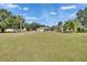 Expansive backyard with lush lawn, mature trees, and ample space for outdoor activities under a beautiful blue sky at 958 Lake Deeson Pt, Lakeland, FL 33805
