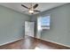 Bright bedroom featuring a ceiling fan, wood floors, and a window with views of the surrounding landscape at 958 Lake Deeson Pt, Lakeland, FL 33805