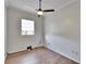 Neutral bedroom with hardwood floors, a ceiling fan, and a window providing natural light at 958 Lake Deeson Pt, Lakeland, FL 33805