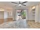 Open living room with tile flooring, ceiling fan, sliding glass door and built-in shelving at 958 Lake Deeson Pt, Lakeland, FL 33805
