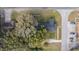 Aerial view of a house and surrounding property with large trees and a paved driveway at 100 Cordova Rd, Auburndale, FL 33823