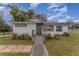 Charming white house with green door, steps, and landscaped yard at 100 Cordova Rd, Auburndale, FL 33823