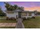 Charming white house with green door, steps, and landscaped yard at 100 Cordova Rd, Auburndale, FL 33823