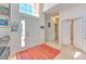 Bright foyer with high ceilings, leading to a laundry room, featuring tile and carpet flooring at 108 Emeraldview Ave, Davenport, FL 33897