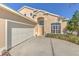 A two-car garage and front entrance of a charming home are nicely landscaped at 108 Emeraldview Ave, Davenport, FL 33897