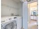 Convenient laundry area with modern washer and dryer, next to a powder room at 108 Emeraldview Ave, Davenport, FL 33897