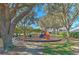 View of neighborhood playground with slide, play equipment, trees and benches at 108 Emeraldview Ave, Davenport, FL 33897