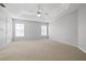 Primary bedroom with tray ceiling, two windows, and carpet at 2003 Rocky Pointe Dr, Lakeland, FL 33813