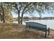 Peaceful lakefront community with a park bench and mature trees at 2003 Rocky Pointe Dr, Lakeland, FL 33813