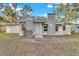 Newly renovated single story home with a gray painted exterior and a brick chimney at 803 E Valencia St, Lakeland, FL 33805