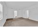 Spacious living area with neutral carpeting and doors to other rooms at 803 E Valencia St, Lakeland, FL 33805