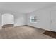 Living room with neutral carpet, built-in shelving, and archway at 803 E Valencia St, Lakeland, FL 33805