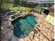 Inviting freeform pool with a stone deck and lush landscaping at 4200 Joslyn Ln, Lady Lake, FL 32159