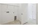 Well-lit laundry room equipped with hookups and shelving, adjacent to a doorway at 1258 Lakeridge Way, Lake Alfred, FL 33850