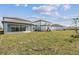 Expansive backyard with lush green grass, landscaping and a modern gray patio at 1622 Ruby Ln, Lake Alfred, FL 33850