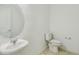 Powder room with a pedestal sink, mirror, and toilet, showcasing a clean, simple design at 1622 Ruby Ln, Lake Alfred, FL 33850