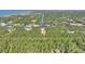 Aerial view showing home on a waterfront lot with lush green surroundings at 4680 Poinciana Dr, Indian Lake Estates, FL 33855