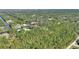Aerial view showing home situated on a wooded waterfront lot at 4680 Poinciana Dr, Indian Lake Estates, FL 33855