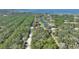 Aerial view highlighting home's location near water and wooded area at 4680 Poinciana Dr, Indian Lake Estates, FL 33855